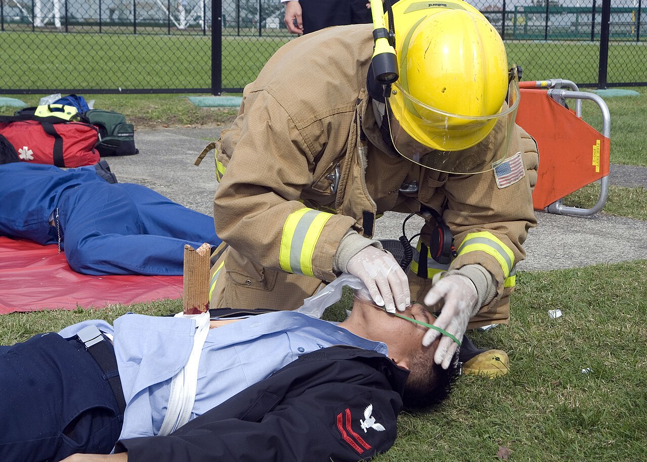 US Navy 081106-N-0483B-002 A firefighter assigned to the Commander, U.S. Naval Forces Japan (CNFJ) regional fire department places an oxygen mask on a simulated victim during a joint mass casualty exercise at Fleet Activities